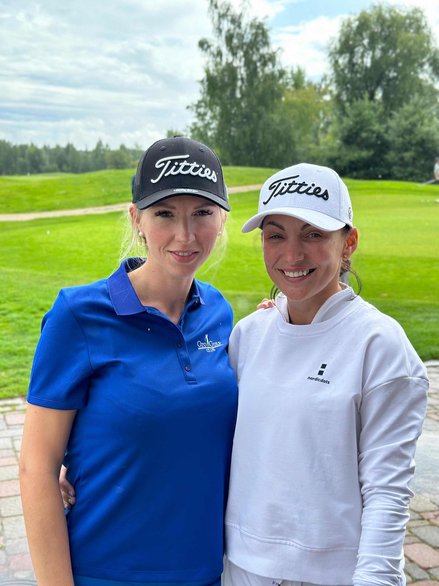 two women wearing titties golf hats